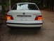 1993 BMW 3 Series - The rear of a white BMW 325i sedan is shown, with its brake lights illuminated.
