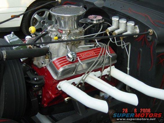 Close-up of a V8 engine with red Chevrolet valve covers and chrome air cleaner