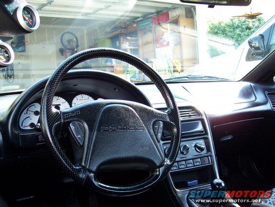 car interior, steering wheel with 'PROBE' text, dashboard, and two gauges on the A-pillar
