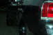 1989 Ford Crown Victoria LTD - A close-up view of the rear side of a black sedan, showing the taillight and wheel well.