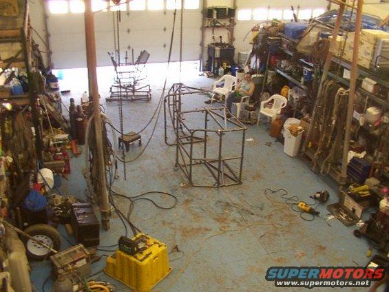 Garage with a metal frame for a vehicle build, tools, and shelves