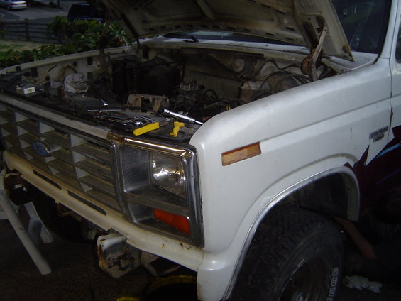 Ford truck with hood open, tools on engine, front end visible