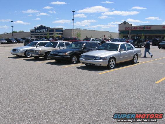 Several sedans parked in a lot, with a Wal-Mart and Dollar Castle in the background