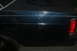 1989 Ford Crown Victoria LTD - Rear quarter panel of a dark blue 1989 Ford Crown Victoria LTD shows significant scratches and dents.