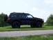 1996 Jeep Grand Cherokee - Modified 1996 Jeep Grand Cherokee parked on a grassy area next to a paved path.