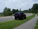 1996 Jeep Grand Cherokee - 1996 Jeep Grand Cherokee parked on a grassy incline beside a paved road under a cloudy sky.