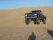 1985 Ford Ranger - A lifted Ford Ranger is captured airborne while cresting a sandy hill under a clear blue sky.