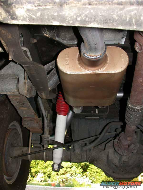 Underside view of vehicle exhaust muffler with 'INLET' text visible