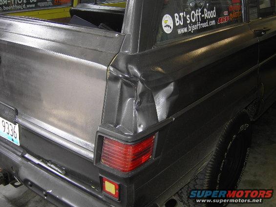 1977 Jeep Wagoneer rear quarter panel shows significant damage near the taillight. License plate 9336 is visible