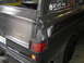 1977 Jeep Wagoneer - Damage to the rear corner of a 1977 Jeep Wagoneer, with a visible license plate.