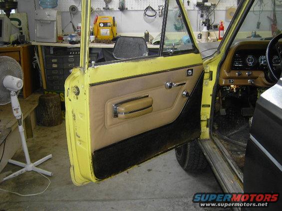 Yellow Jeep Wagoneer interior showing door panel and dashboard
