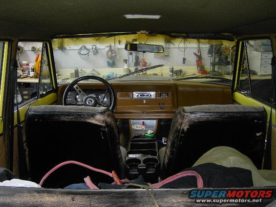 1977 Jeep Wagoneer interior showing front seats, dashboard, steering wheel, and center console
