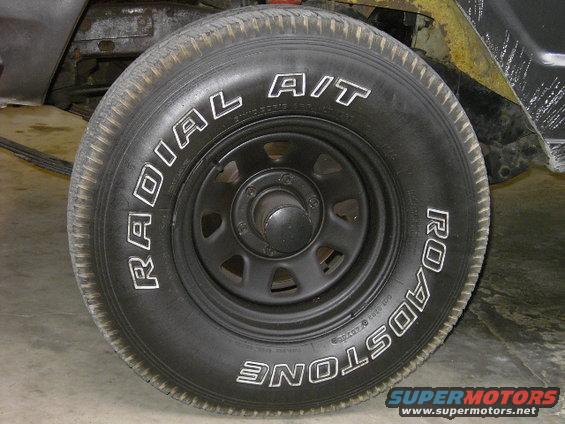 Close-up of a black tire with white lettering that says RADIAL A/T and ROADSTONE