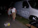 1978 Ford Mustang II - A van with flame graphics is parked on asphalt at night, with people standing nearby.