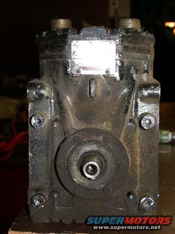 Black air conditioning compressor with a white label reading "Motorcraft"