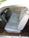 1966 Ford Ranchero - Interior view of a white vehicle, showing light gray bench seats and a blue and black steering wheel.