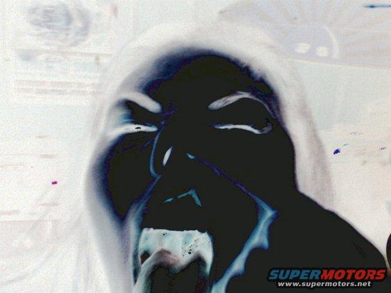 Close-up of a person's face with mouth open in a scream, inverted colors