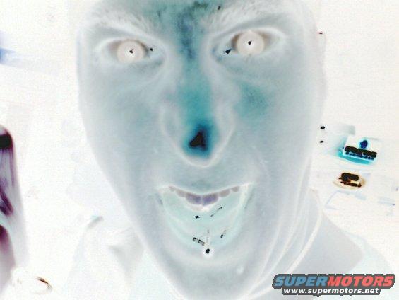 Inverted image of a person's face with wide eyes and an open mouth, showing teeth. Text 'SUPERMOTORS' is visible in the lower right corner