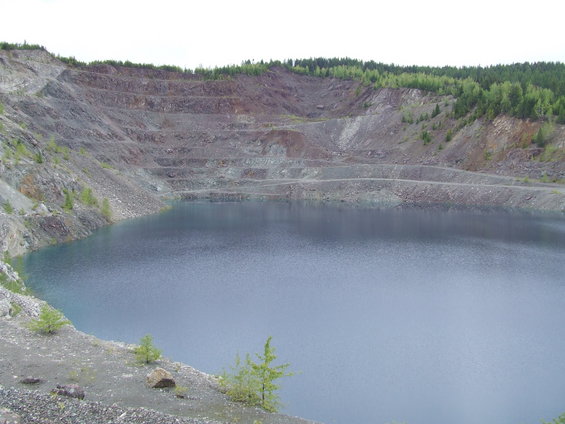 Quarry with blue water and terraced rock walls