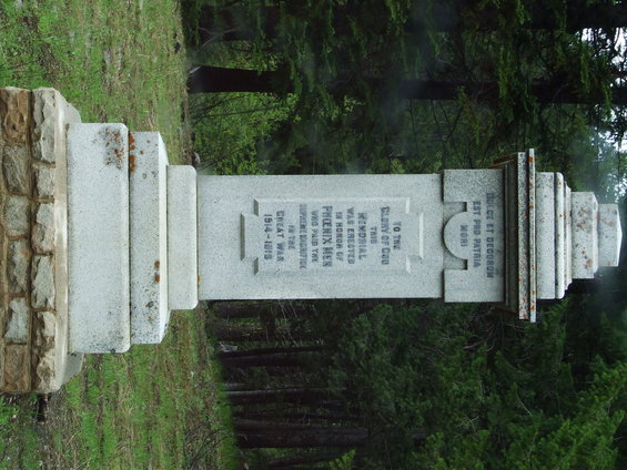 War memorial with inscriptions, set in a forest