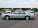 2002 Ford Crown Victoria - Side view of a light blue 2002 Ford Crown Victoria sedan parked outdoors with other vehicles visible in the background.