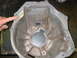 1993 Ford Taurus - A person's finger points to a damaged section of a metal transmission bell housing.