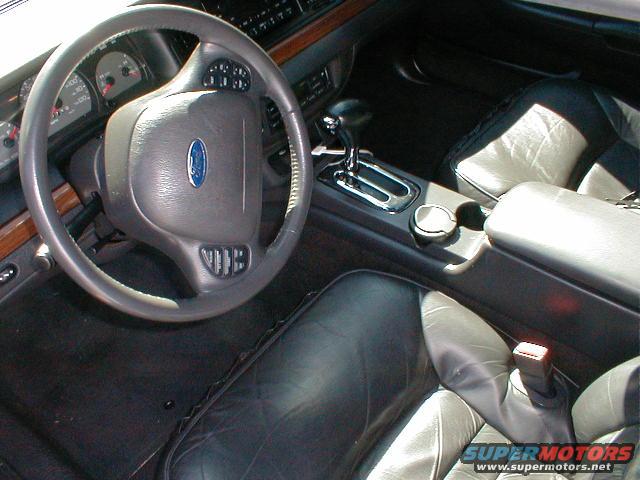 2002 Ford Crown Victoria interior showing leather seats, steering wheel with Ford logo, and center console with gear shifter