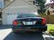 2002 Ford Crown Victoria - Rear view of a black 2002 Ford Crown Victoria parked in front of a garage.