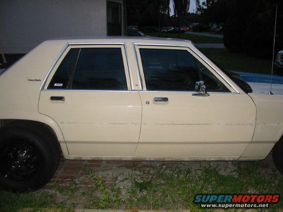 Tan four-door sedan with chrome trim and tinted windows, seen from the side