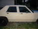 1985 Ford Crown Victoria LTD - A tan sedan with a distinctive body style is parked outdoors.
