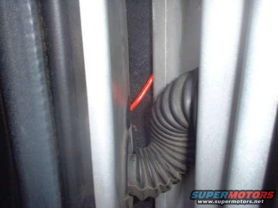 wirerouting1.jpg Amp wire running through rubber plug in door jam