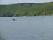 1988 Ford Bronco - Two people ride a jet ski on a calm lake, with a wooded hillside in the distance.