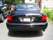 2003 Mercury Marauder - The rear of a black Mercury Marauder is shown, parked in a driveway with a pickup truck beside it.