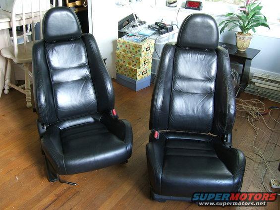Two black leather car seats with adjustable headrests
