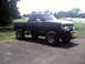 1996 Ford Bronco - A modified pickup truck with a lifted suspension and oversized tires sits on a paved surface outdoors.