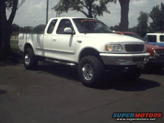 White Ford F-150 pickup truck, 1997 model year, parked outdoors. Another vehicle is partially visible to the right