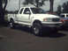 1996 Ford Bronco - White 1997 Ford F-150 pickup truck seen from the front-right angle.