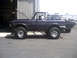 1996 Ford Bronco - Side view of a purple Ford Bronco, hood up, with a second vehicle behind it.