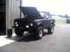 1996 Ford Bronco - This Ford Bronco is parked outside a garage with its hood up, showing off its engine bay.