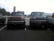 1996 Ford Bronco - Two pickup trucks are parked next to each other in a parking lot.
