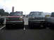 1996 Ford Bronco - Two trucks are parked in a lot under a cloudy sky. The red truck is on the left and the green truck is on the right.