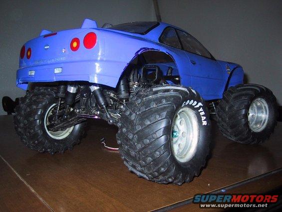 Blue RC monster truck with large tires, modified body, and visible suspension