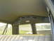1990 Chevrolet Suburban - View from inside a vehicle's rear seat, looking out the window at another SUV and a suburban neighborhood.