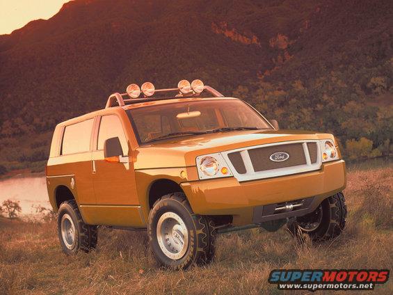 Orange concept SUV with roof rack and off-road tires parked in a grassy field
