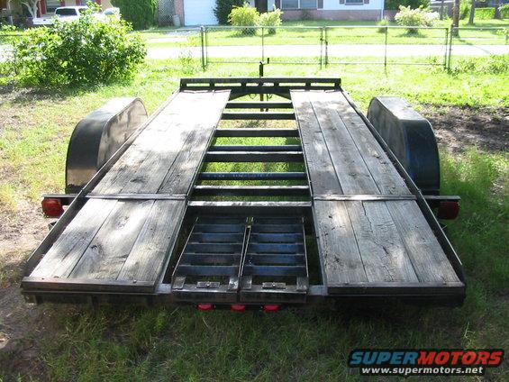 Car hauler trailer rear view with wooden deck and metal ramps