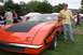 1970 Ford Ranchero - Man stands next to a bright orange 1970 Ford Ranchero at an outdoor car show.