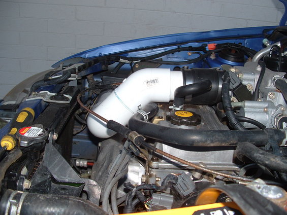 Custom white PVC intake pipe on engine