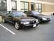 2003 Mercury Marauder - Two black sedans are parked side-by-side in a parking lot.