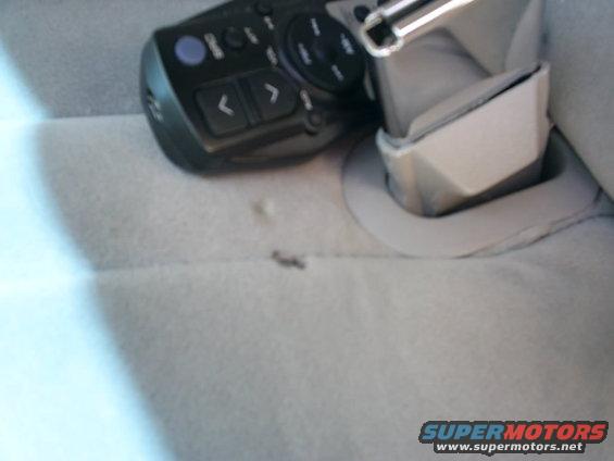 Seatbelt buckle and remote control on gray upholstery