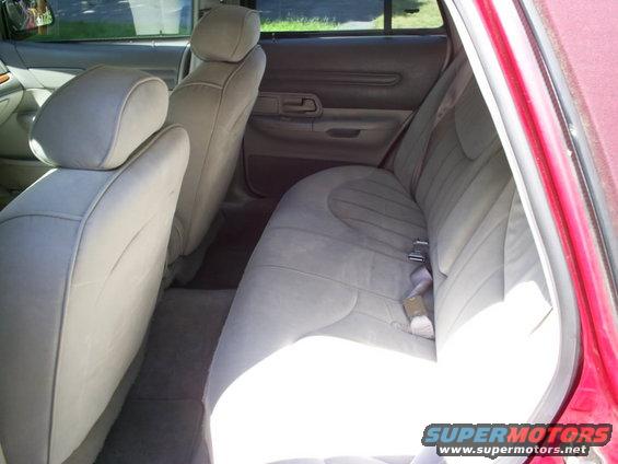 Back seat and door panel of a car. Light tan seats and gray door trim